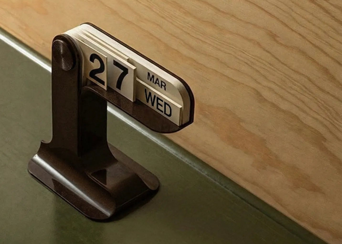 Calendar clip on a green surface with wooden background