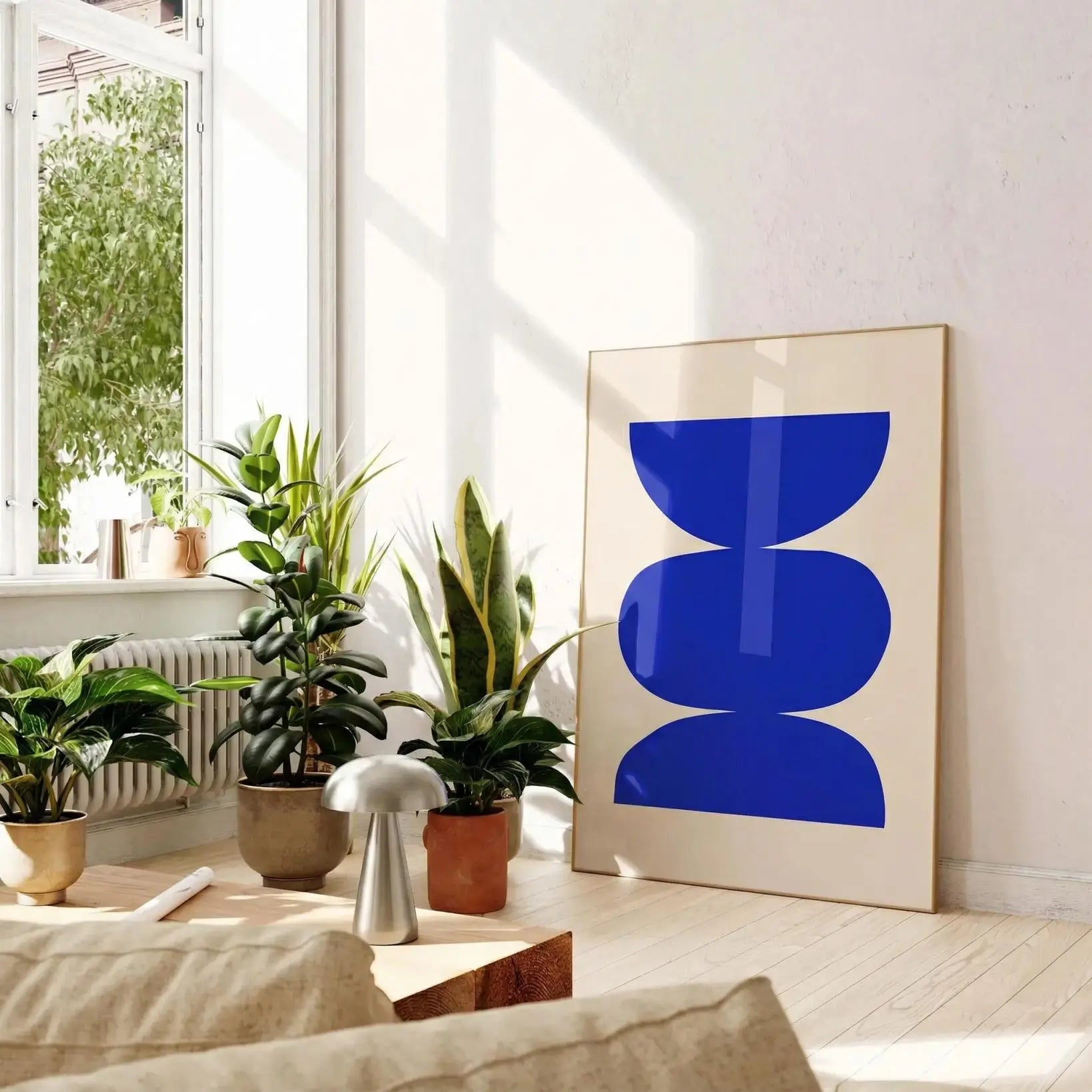 Modern living room with plants and a blue abstract art piece on the wall