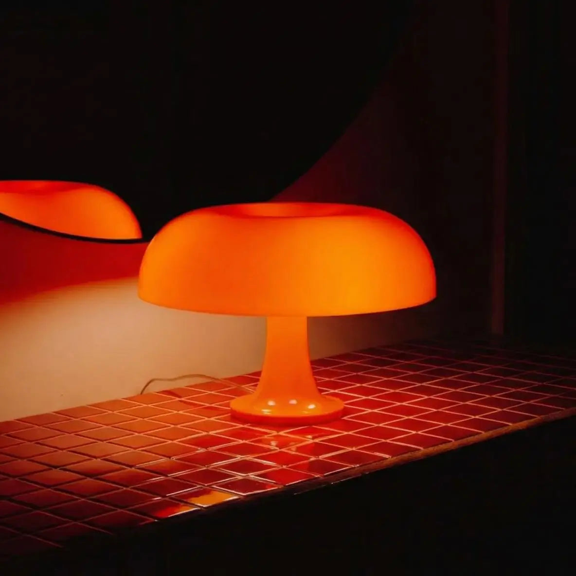 Orange table lamp on a tiled surface with a dark background