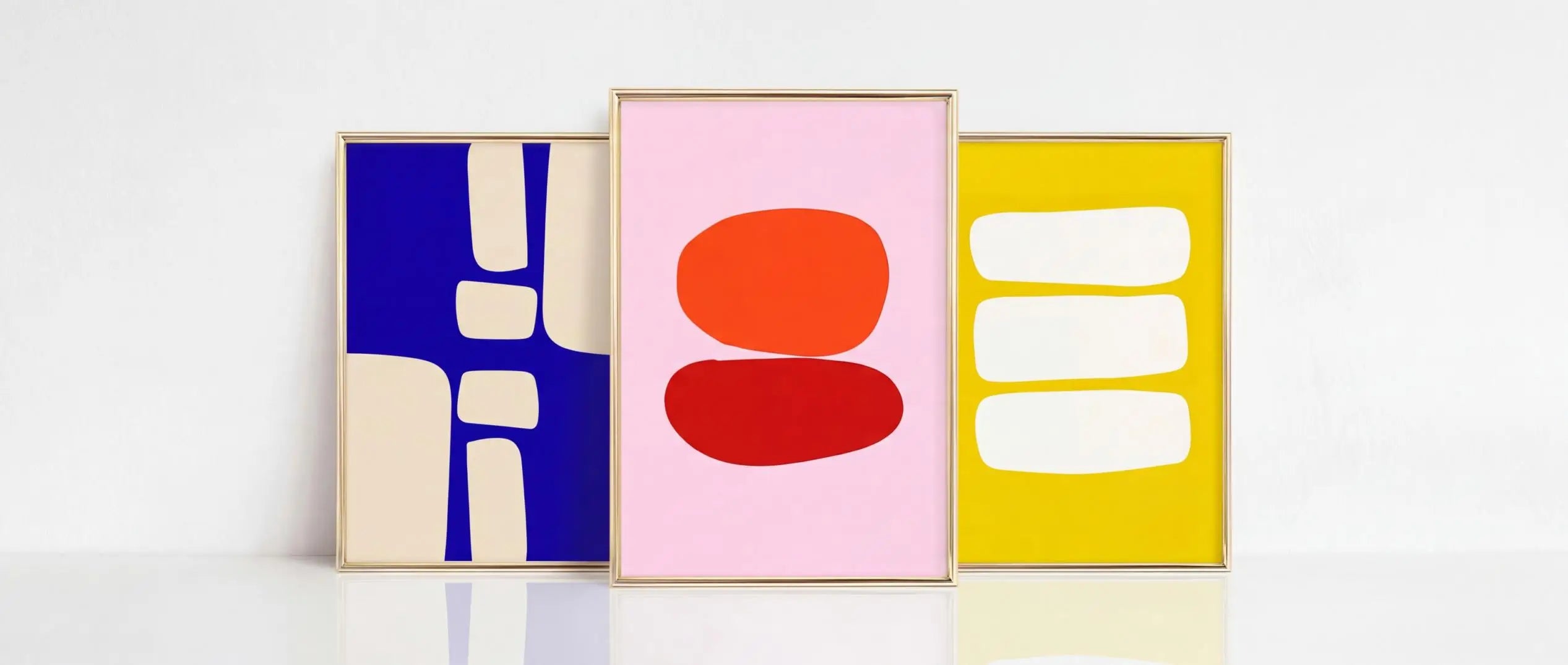 Three abstract art prints in blue, pink, and yellow on a white background