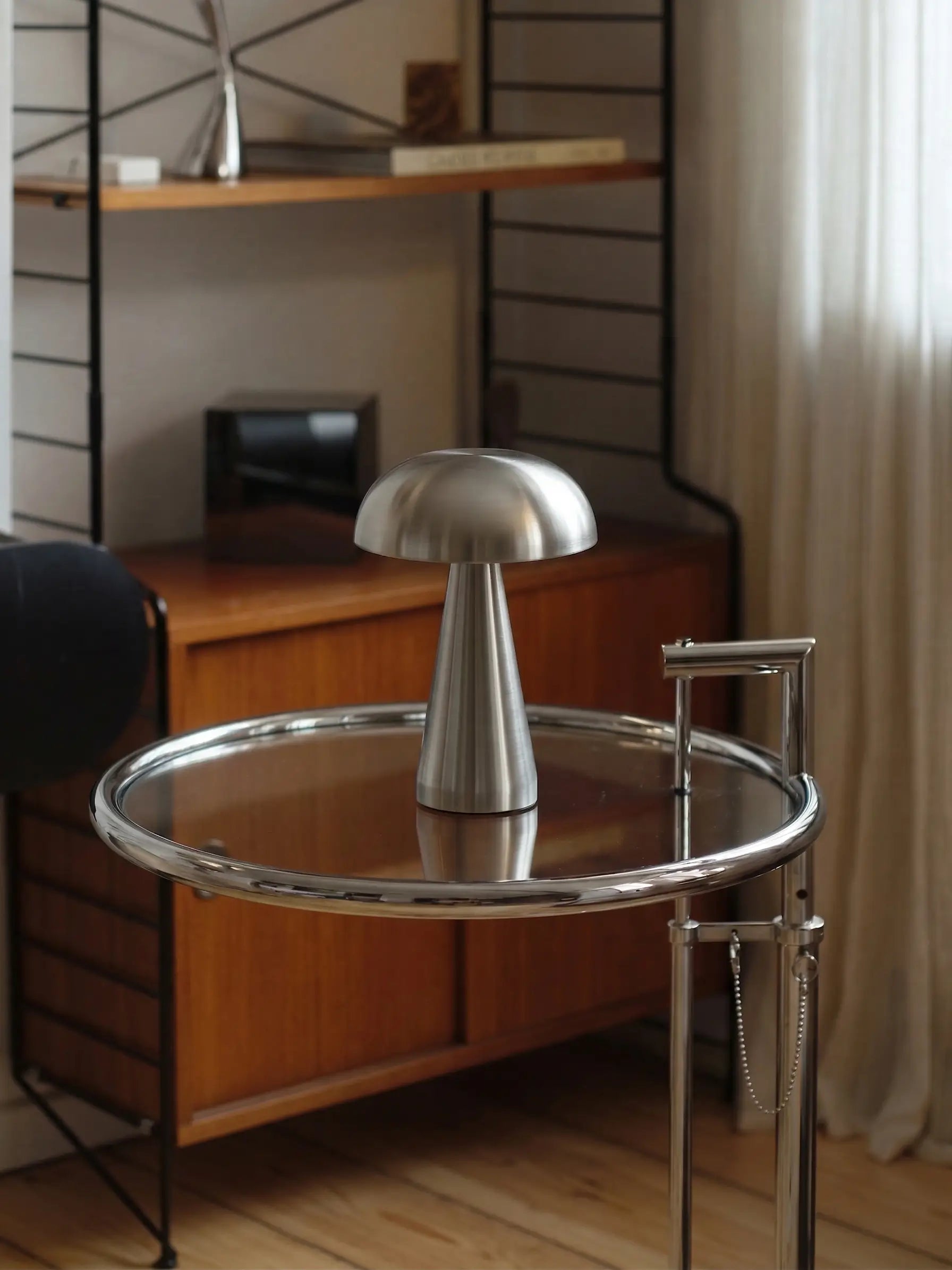 Modern round glass table with metallic base in a room setting