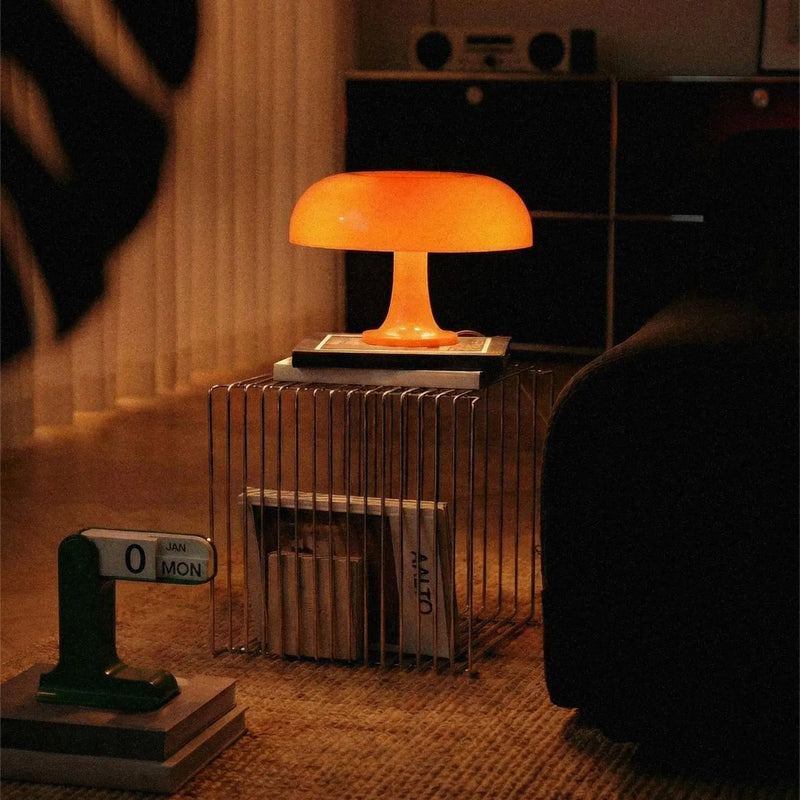 Table lamp with a warm glow on a nightstand in a dimly lit room.